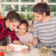 Three young sisters video chat near Thanksgiving ingredients